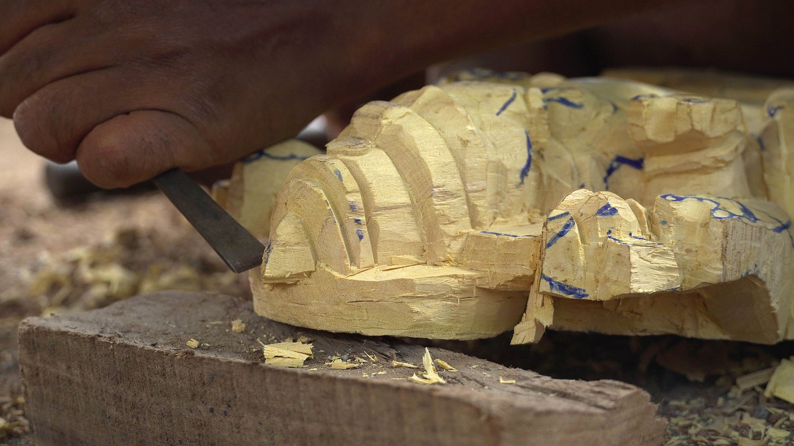 Artisan hand-carving a wooden sculpture